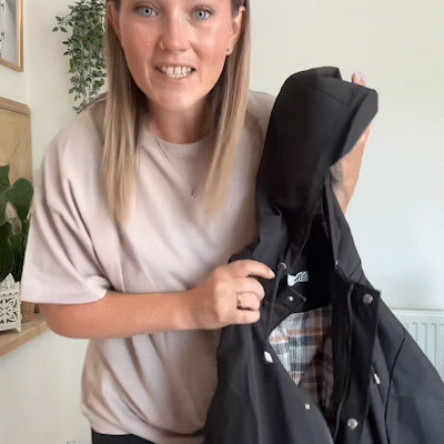 Vrouw toont de Carlotta regenjas in zwart met geruite voering – Elyssor Fashion